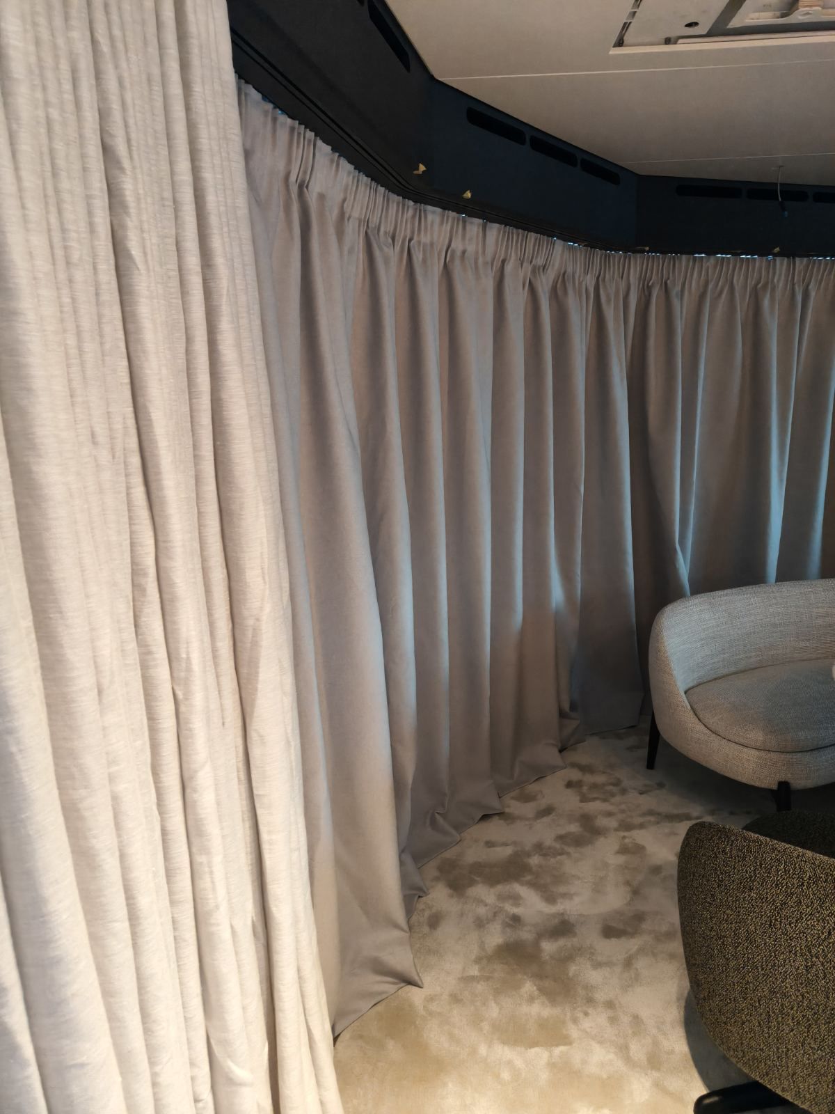 Sheer and blackout curtain layers meeting at a curved corner