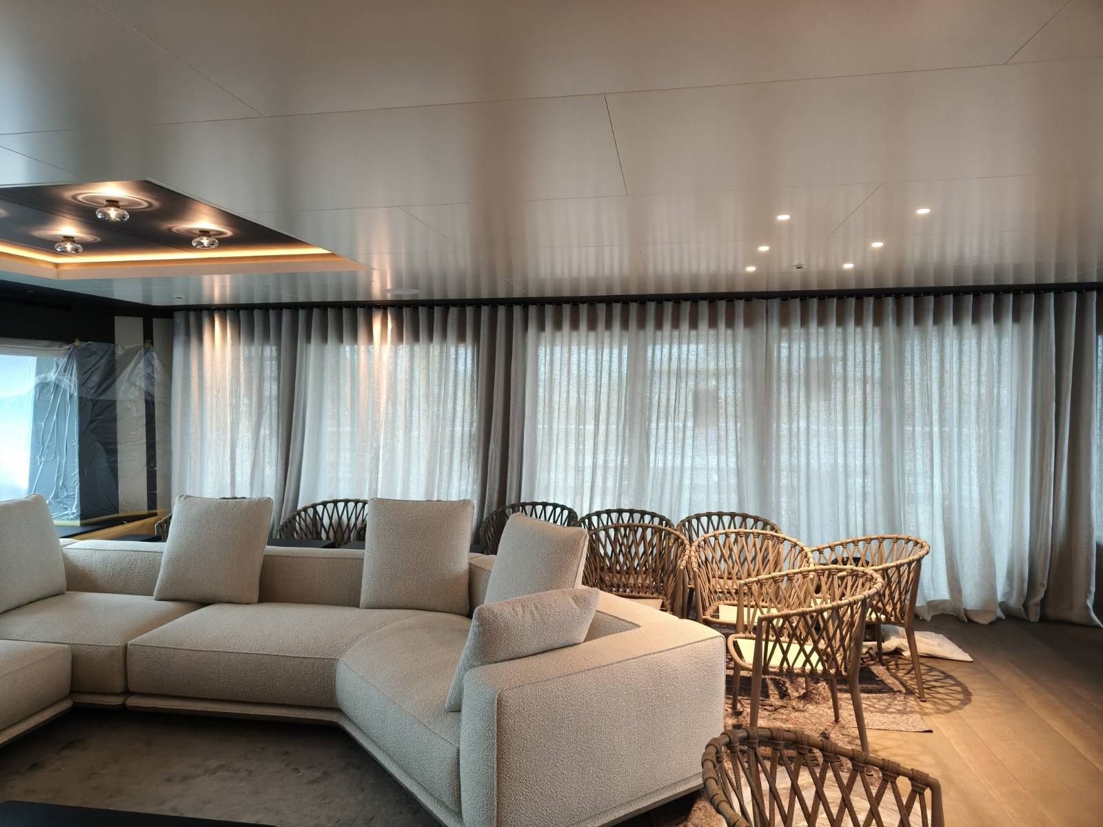 Saloon lounge with sheer curtains and upholstered seating