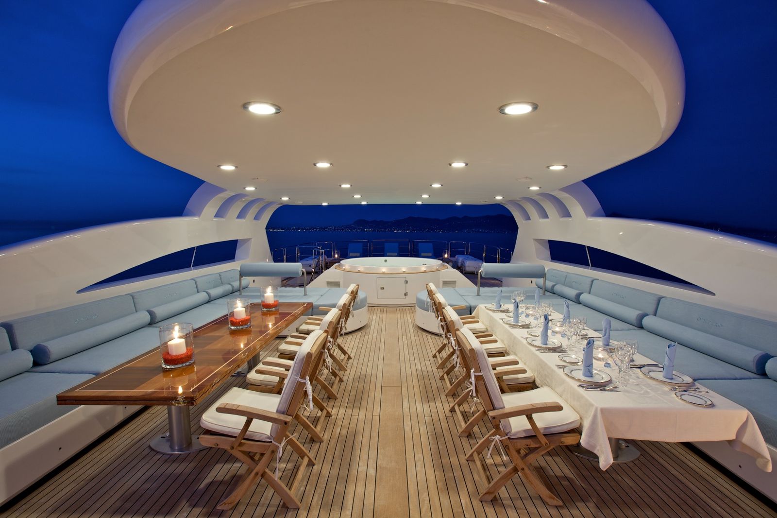 Yacht exterior dining deck with custom teak flooring and seating